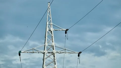 Metal pole with high-voltage wires against a cloudy sky. Stock Footage 158955897