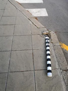 A metal pole is lying at the intersection, as a result of an accident. Stock Photos