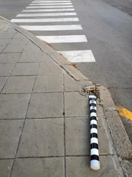 A metal pole is lying at the intersection, as a result of an accident. Stock Photos