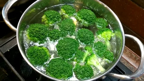 A metal pot of boiling water containing bright green broccoli Stock Footage 339235887