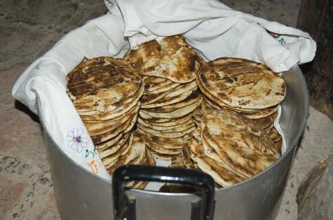 Metal pot on the floor full of small corn bread. Ecuador Stock Photos