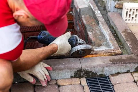 Metal processing with a grinder with a cutting disc. Bulgarian saw in the han Stock Photos