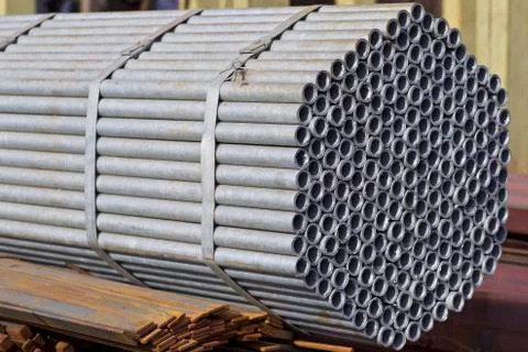 Metal profile pipe of round section in packs at the warehouse of metal produc 库存照片