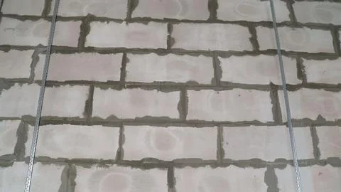 Metal profiles supporting a cinder block wall during construction Stock Photos