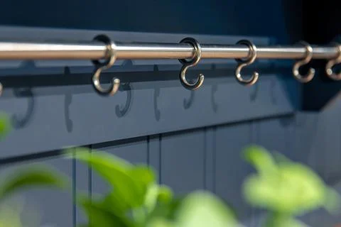 Metal rack for kitchenware on a blue kitchen background. Stylish interior a.. Stockfoto's