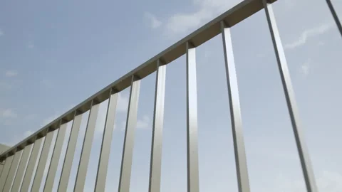 Metal railing creates geometric pattern along blue sky Stock Footage 346020089