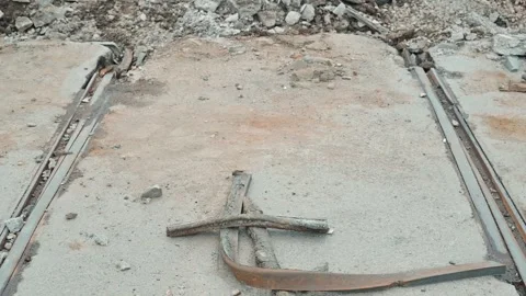 Metal rails lie on a concrete surface at an urban construction site. Surrounding Vidéo 339095853