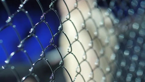 Metal ring mesh. Mixed types of martial arts. The athlete is preparing for the Stock Footage 150370302