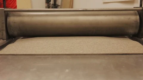 Metal roller is used to flatten material in a workshop. Elastic material Stock Footage 116885899