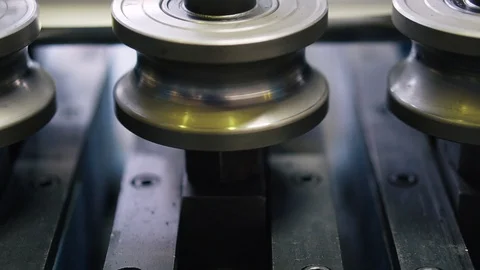 Metal rollers in a complex machine rotate on pins in a new factory machine Stock Footage 115935728