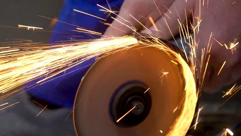 A metal saw with a disc grinder in a workshop. Sparks fly out of the circle Stock Footage 115438348