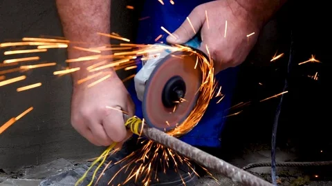 A metal saw with a disc grinder in a workshop. Sparks fly out of the circle Stock Footage 115438699