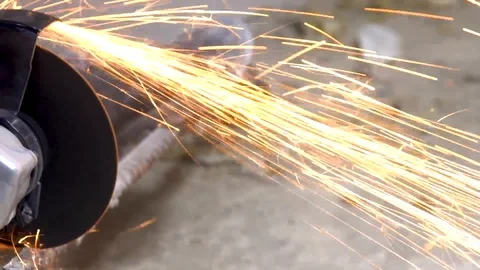 A metal saw with a disc grinder in a workshop. Sparks fly out of the circle Stock Footage 115439022
