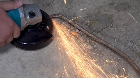 A metal saw with a disc grinder in a workshop. Sparks fly out of the circle Stock Footage 115439064