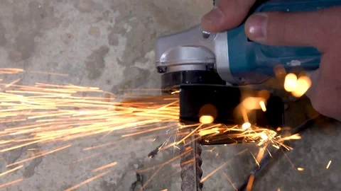 A metal saw with a disc grinder in a workshop. Sparks fly out of the circle Stock Footage 115439377