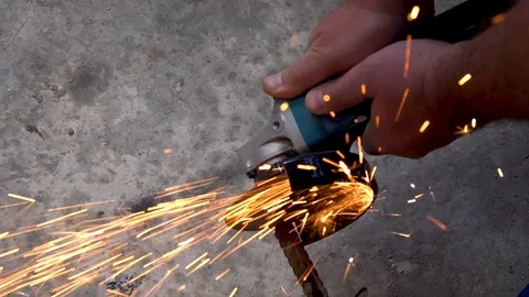 A metal saw with a disc grinder in a workshop. Sparks fly out of the circle Stock Footage 115439519