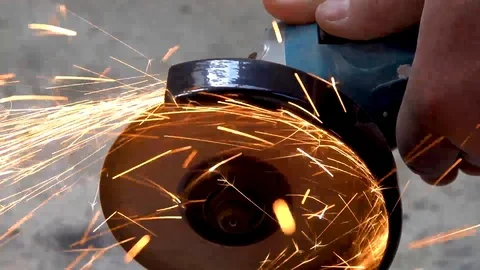A metal saw with a disc grinder in a workshop. Sparks fly out of the circle Stock Footage 115439537