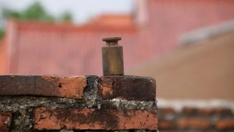 Metal scale on brick rooftop wall held by a man's hand Stock Footage 312056089