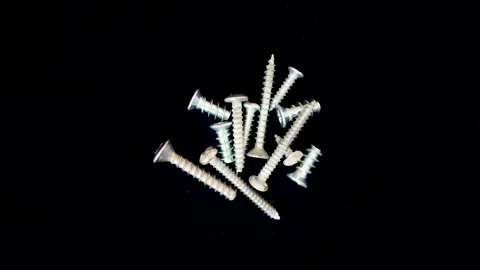 Metal screws rotating in sync against a black background, industrial and Stock Footage 303130437