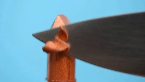 Metal sharp knife cuts lipstick into slices on a blue background. Video stock 107986033