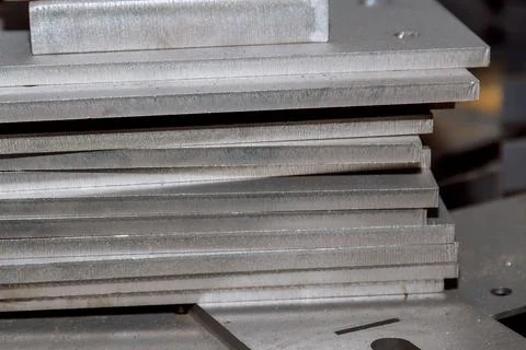 The metal sheet is cut on a CNC laser cutting machine. Metal parts are cleane Stock Photos