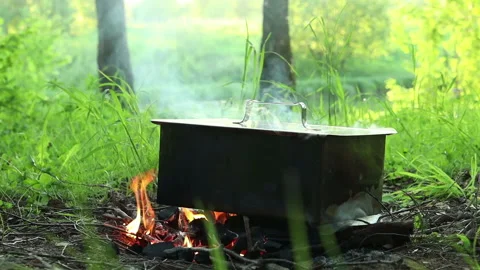 a metal smoker is Smoking on the fire | Stock Video | Pond5