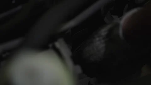 Metal socket wrench tool laying inside a dark car engine compartment Video stock 338365506
