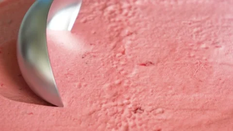 Metal spoon making cold pink ice cream ball strawberry bites close up background Stock Footage 156210041