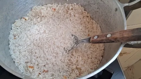 Metal spoon stirring white rice inside aluminum cooking pot footage Stock Footage 339249073