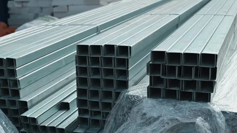 Metal square tubes are stacked for storage in a facility. The arrangement shows Stock Footage 339095924