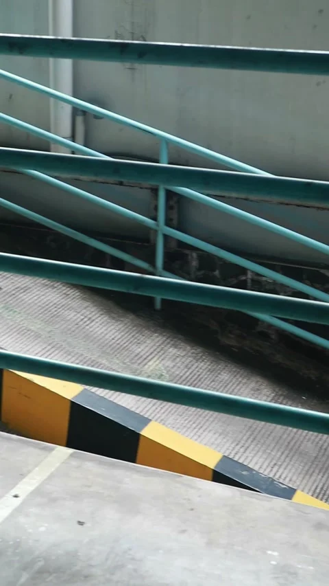 Metal staircase with a teal railing on a gray concrete background Stock Footage 330281401