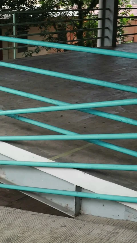 Metal staircase with a teal railing on a gray concrete background Stock Footage 330281433