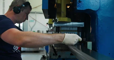 Metal stamping press with operator loading sheet metal in factory workshop Stock Footage 336302099