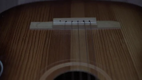 Metal strings stretch along nice expensive wooden guitar Stock Footage 120245771