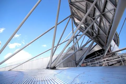 Metal structure of a roof with a complex shape on a sunny blue sky Stock Photos