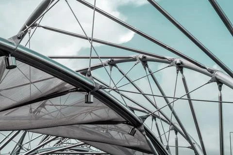 Metal structures with mesh and cables under a blue sky, forming an abstract Stock Photos