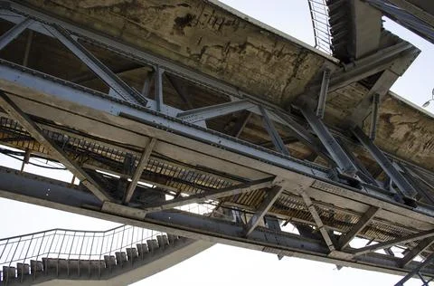 Metal structures under the bridge, large metal bridge over water. View from Stock Photos