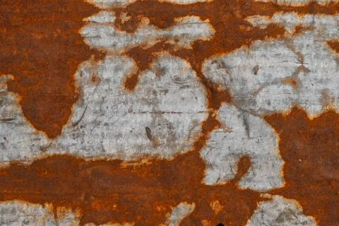 A metal surface displays a weathered texture with shades of rust and gray. The Stock Photos