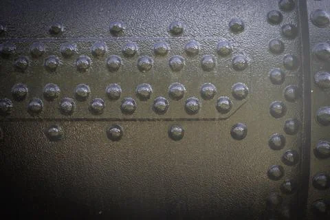 A metal surface with many small, round, black dots Stock Photos