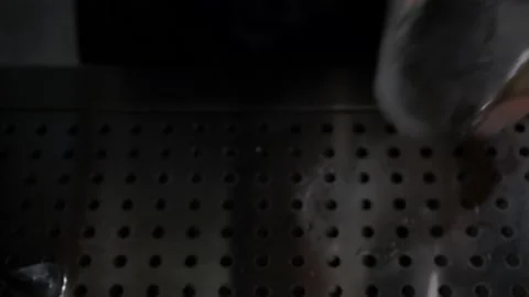 On metal surface,bartender puts empty glass,pouring ice cubes into it.Close-up Stock Footage 130889189