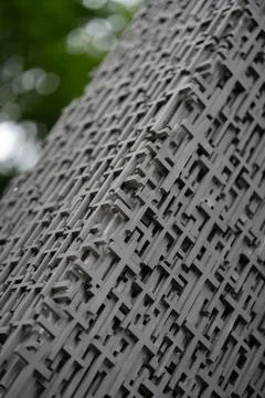 Metal texture with a repeating cross pattern on a monument column sculpture. Stock Photos