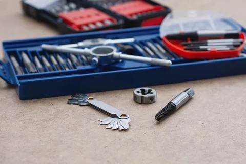 Metal thread cutting tap and die set with handle, drill bits, and gauges ar.. Stock Photos
