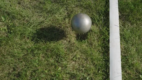 A metal throwing ball falls on the lawn next to the markings Stock Footage 320393226