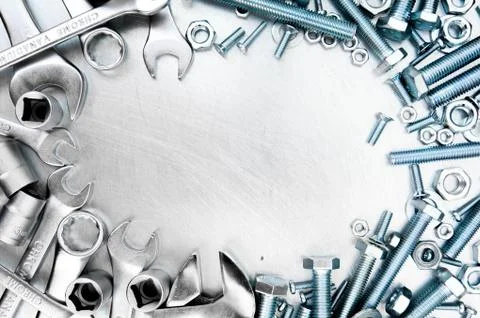 Metal tools and fixing elements on the scratched metal background. Stock Photos