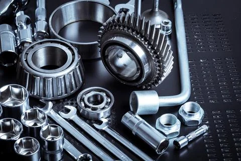 Metal tools and mechanical components arranged on a dark surface showcasing Stock Photos