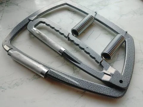 A metal trainer for the development of hand grip is lying on the table 写真素材