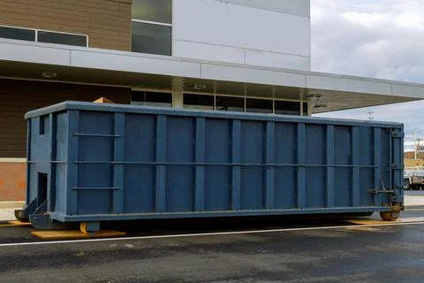 Metal trash construction garbage dumpster on the house renovation Stock Photos
