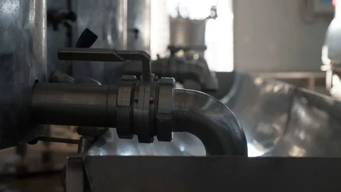 A metal trough held between cylindrical tanks with taps. Stock Footage 127885702