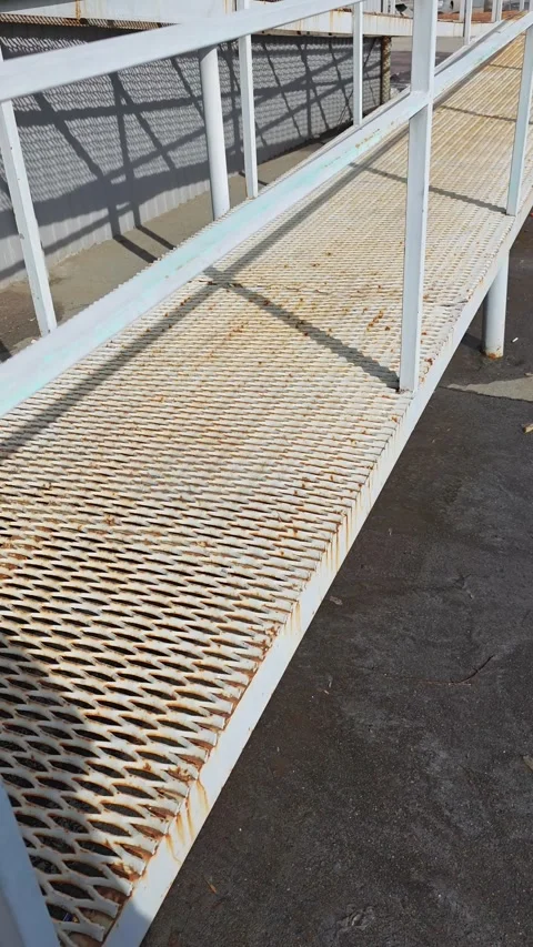 Metal walkway with rusted surface and railings, showing gradual perspective Stock Footage 331635115