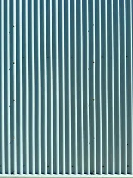 Metal wall with vertical lines and small marks captured during bright dayli.. Stock Photos